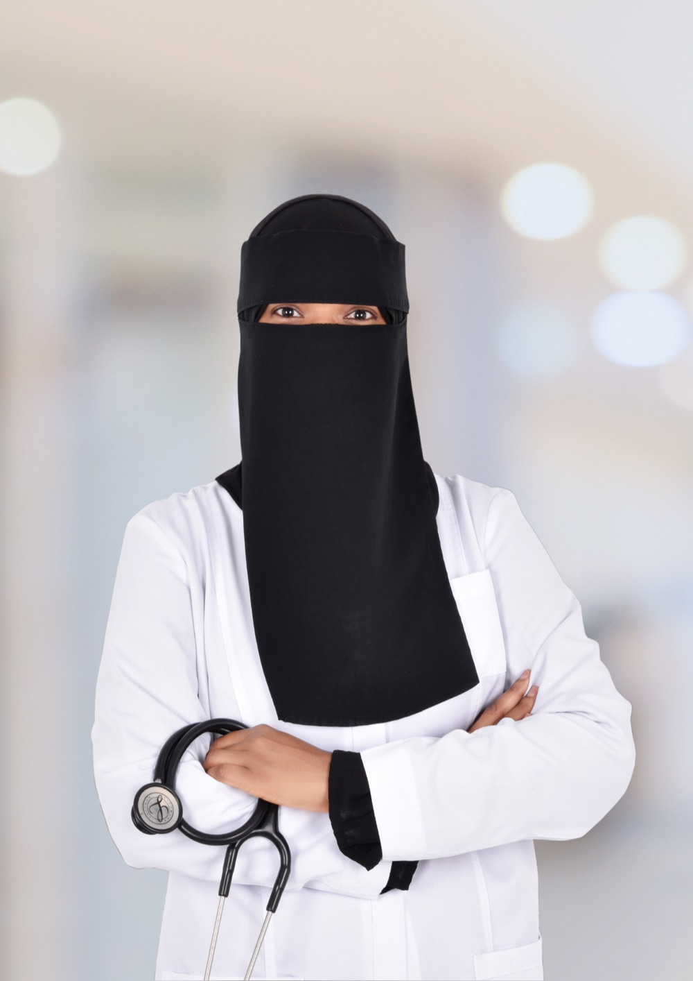 Dr Farida Fanda, GP at FanCare Clinic, in a white coat holding a stethoscope